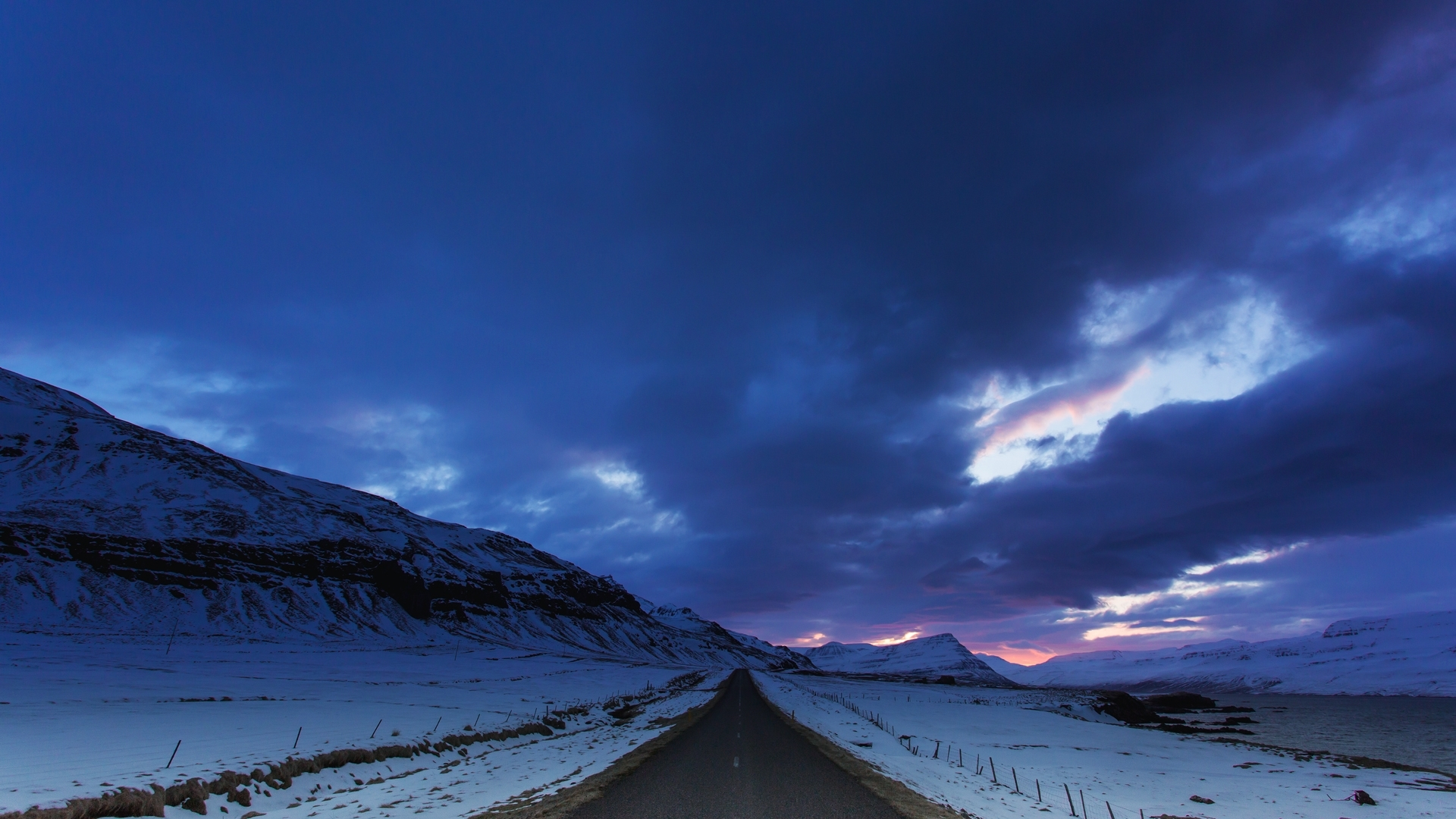 En väg i skymning genom ett vinterlandskap